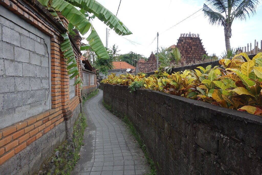 A quiet Ubud gang (lane) between walls — the calm is a few steps off the main road.