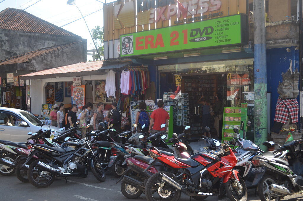 Motorbikes parked three-deep outside the shops — how most people actually get around.
