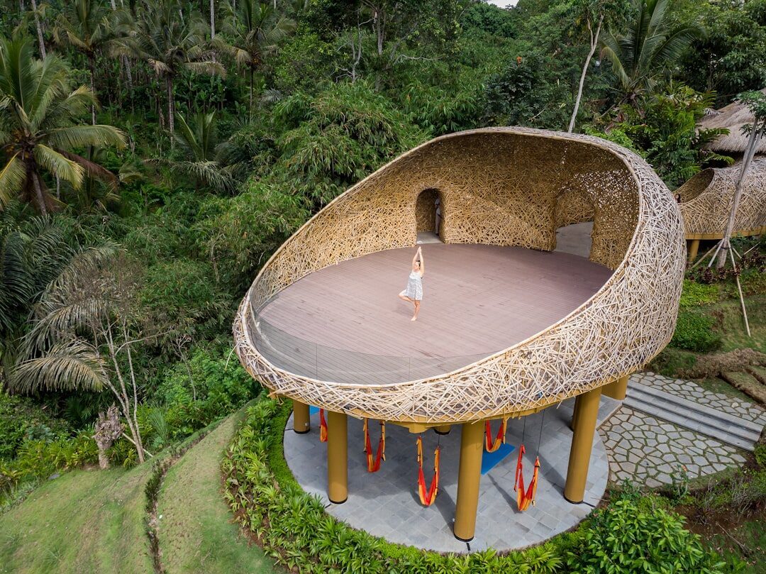 A round meditation pavilion set into the jungle above the valley — the high end of the retreat scene.
