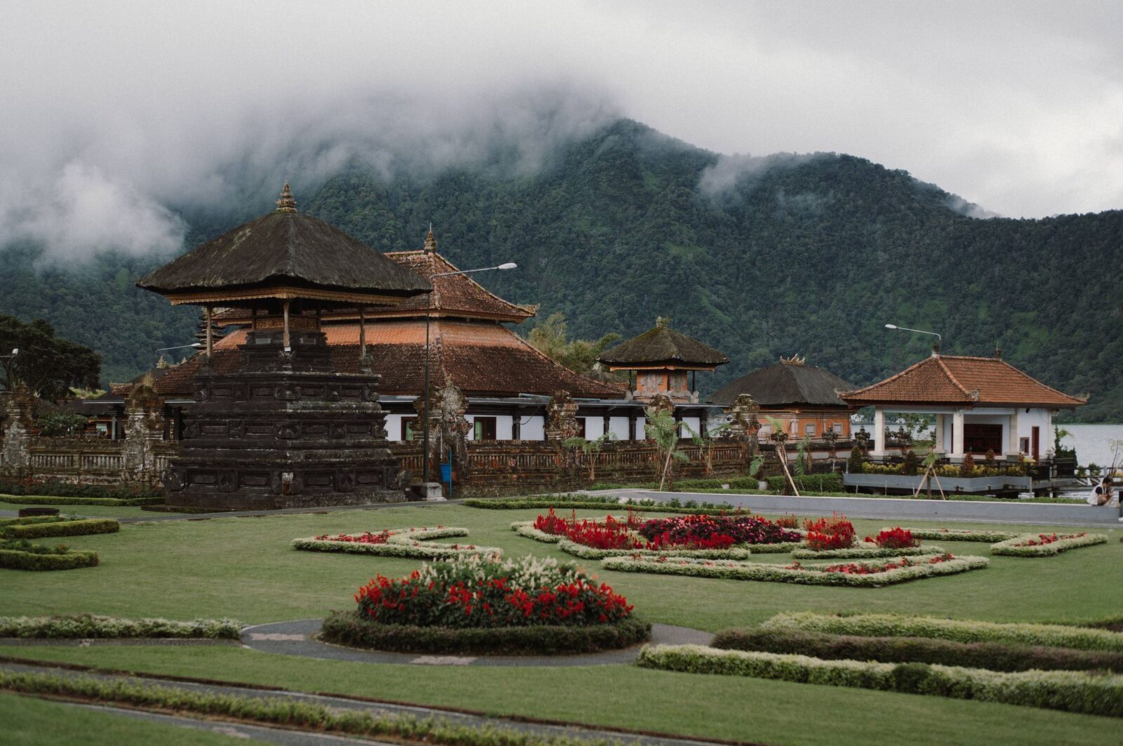 Red flower beds and trimmed lawns between the shrine pavilions — the recreation-park side of the site.