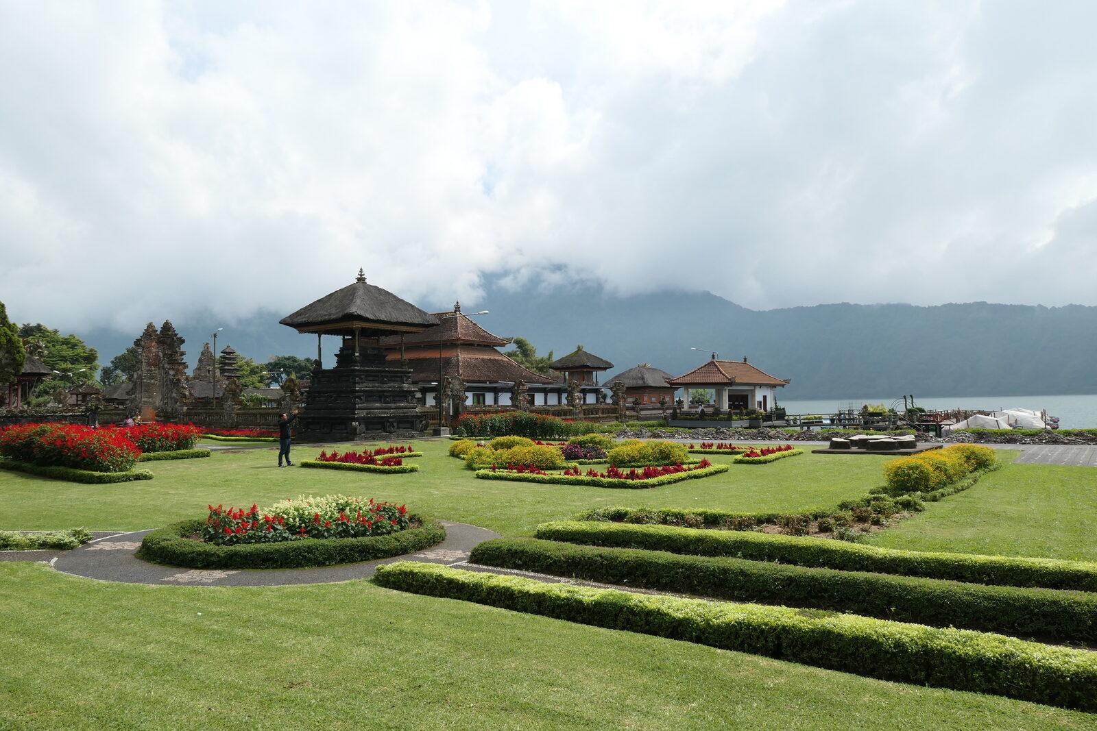 The manicured lake park: clipped lawns, hedges and flower beds run down to the water and the pavilions.