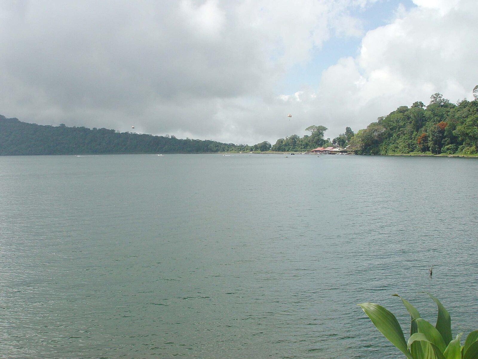 The broad sweep of Lake Beratan, forested hills fading into cloud on the far shore.