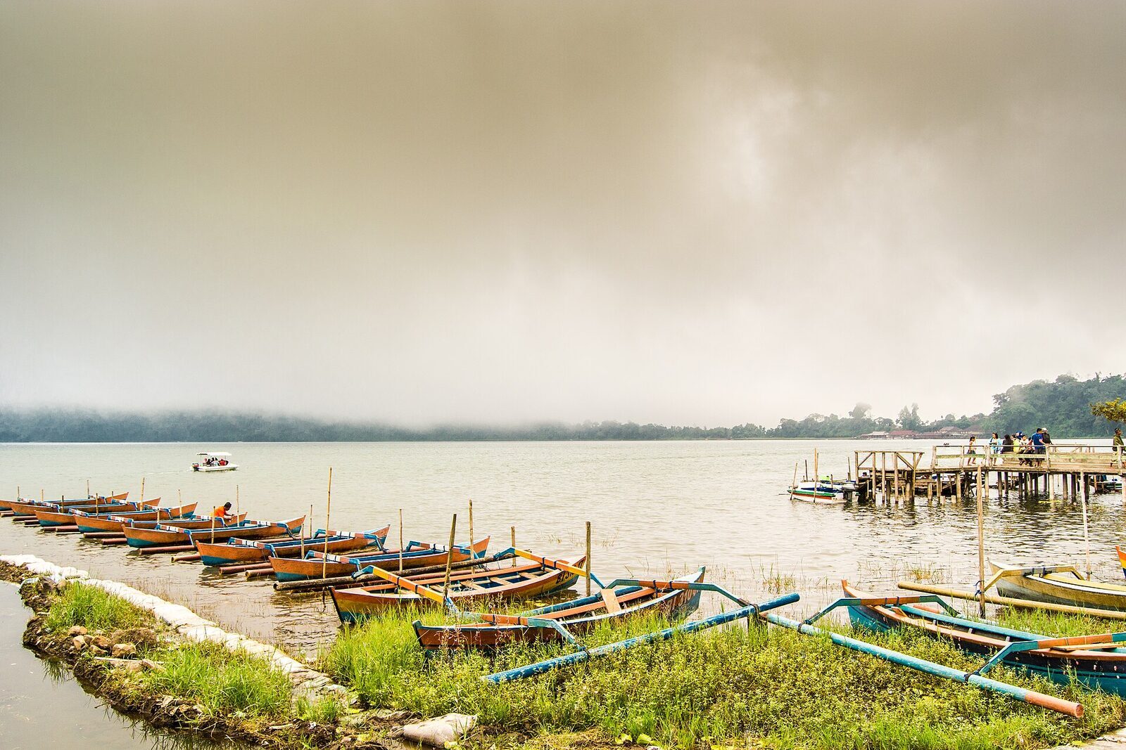 Fishermen's jukung drawn up along the misty lakeshore.