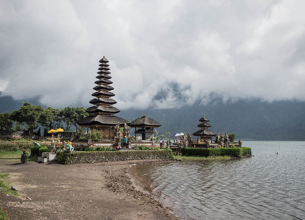 The temple from along the shoreline, the water lapping close to the paths.