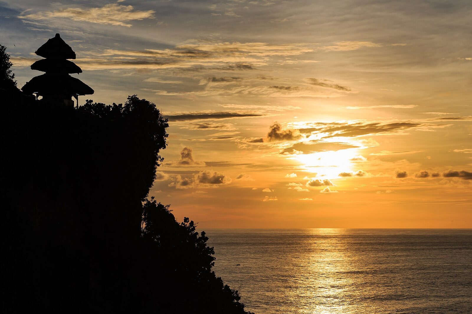 Dusk on the headland, the meru in silhouette — the cliff where tradition says Nirartha 'went up'.