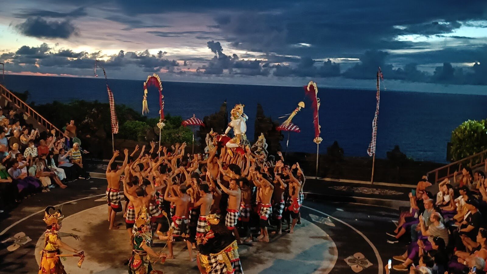 The stage at blue hour, the circle lit against a darkening sea.