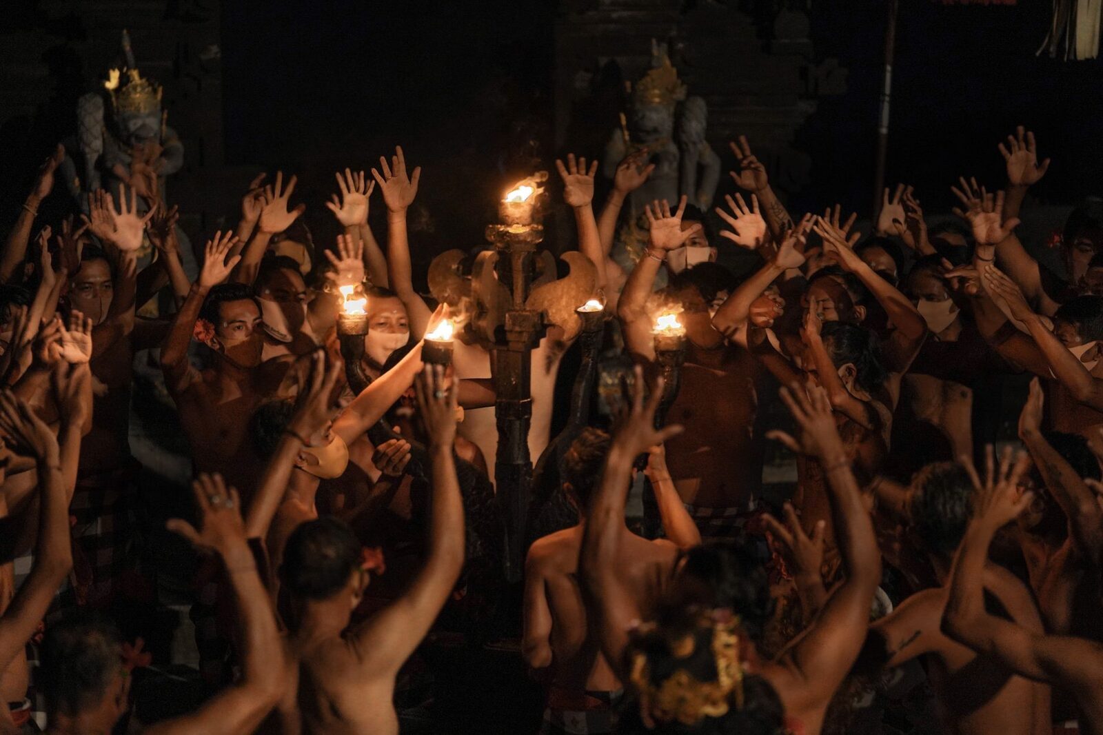 Hands raised on the 'cak' — the interlocking chant that carries the whole show.