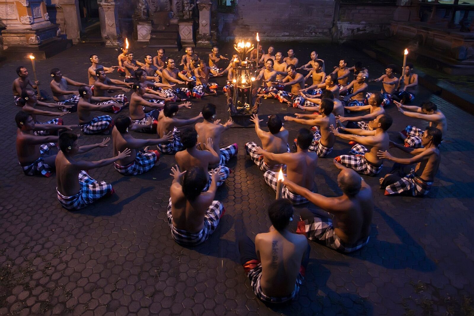 The chanting ring by torchlight — dozens of men splitting one fast rhythm between them, with no gamelan in sight.