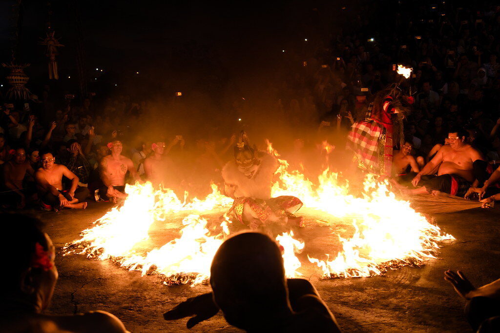 The bonfire at the centre, a figure moving through it.