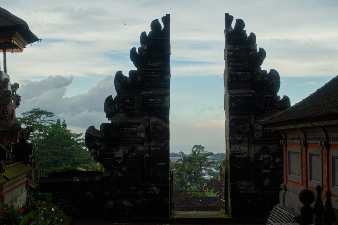 A candi bentar — the split gate cleanly divided down the middle, its inner faces left sheer as if cleaved. The form marks the outer boundary of the sacred compound.