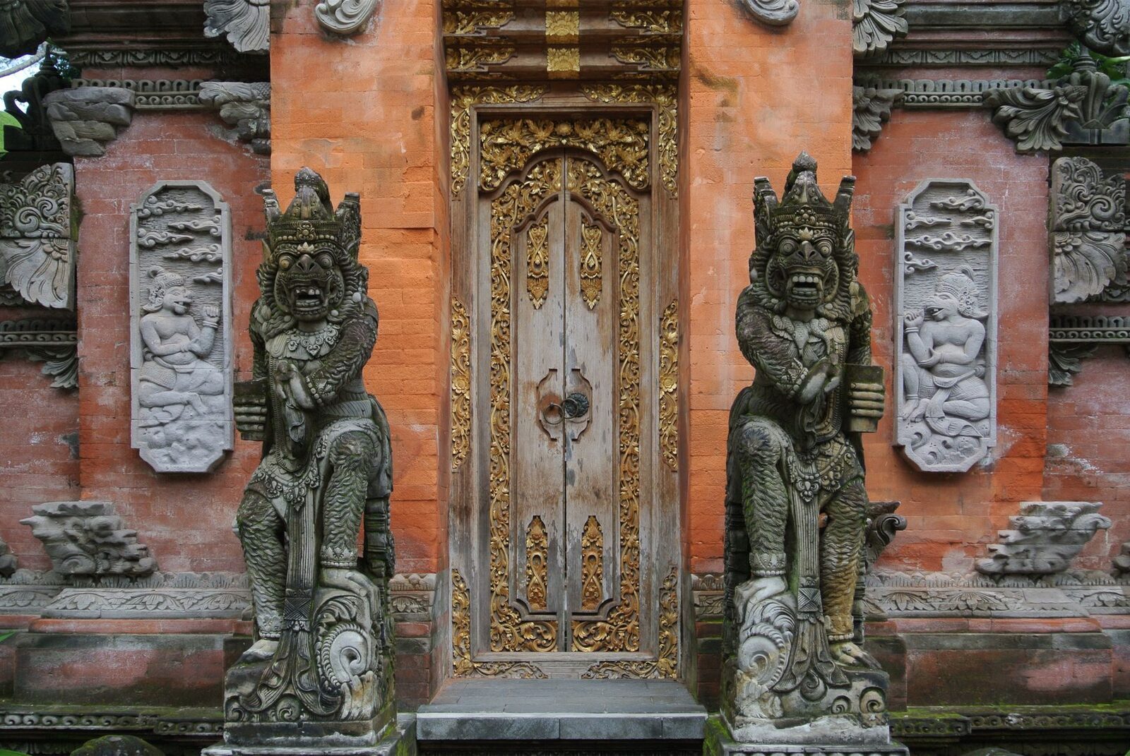 A carved doorway flanked by two stone guardians.