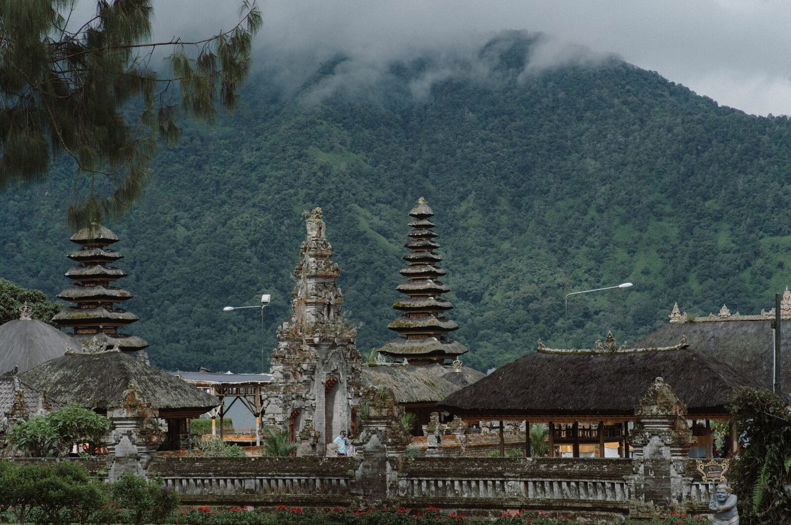 A cluster of meru towers below a mountain — a general view of the tiered shrine form.
