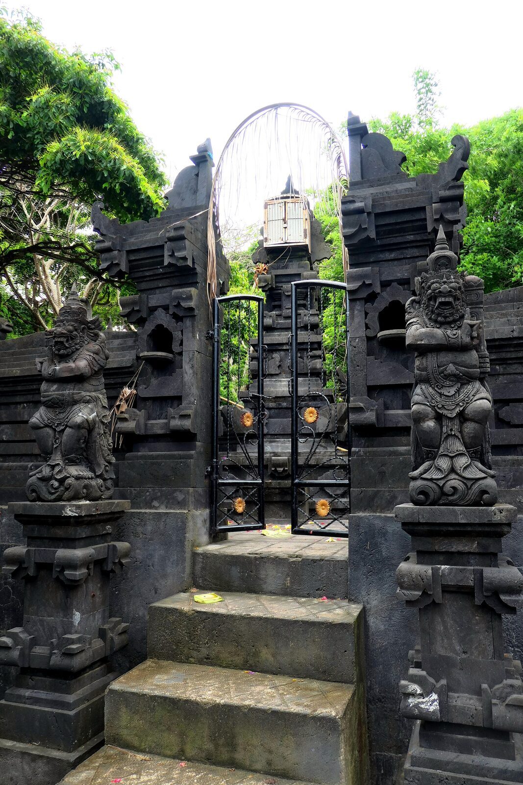 A carved gateway and guardian figures at Uluwatu temple