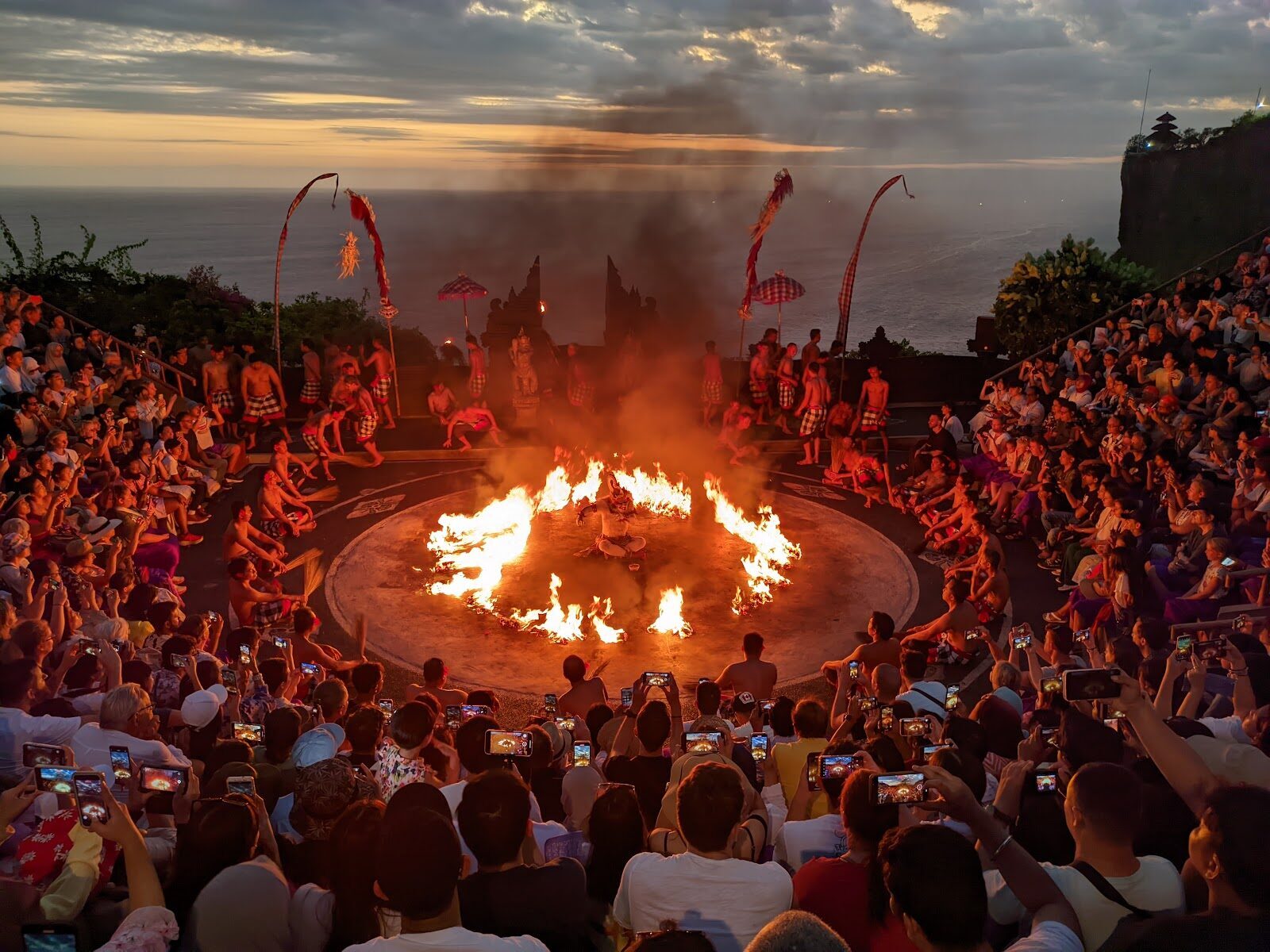 The fire circle at dusk, ocean beyond, at the Uluwatu Kecak.