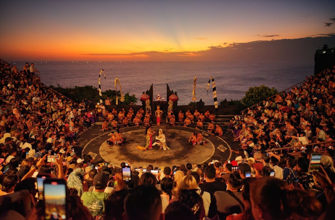 The open-air Uluwatu amphitheatre at sunset, the sea behind, as the Kecak begins.