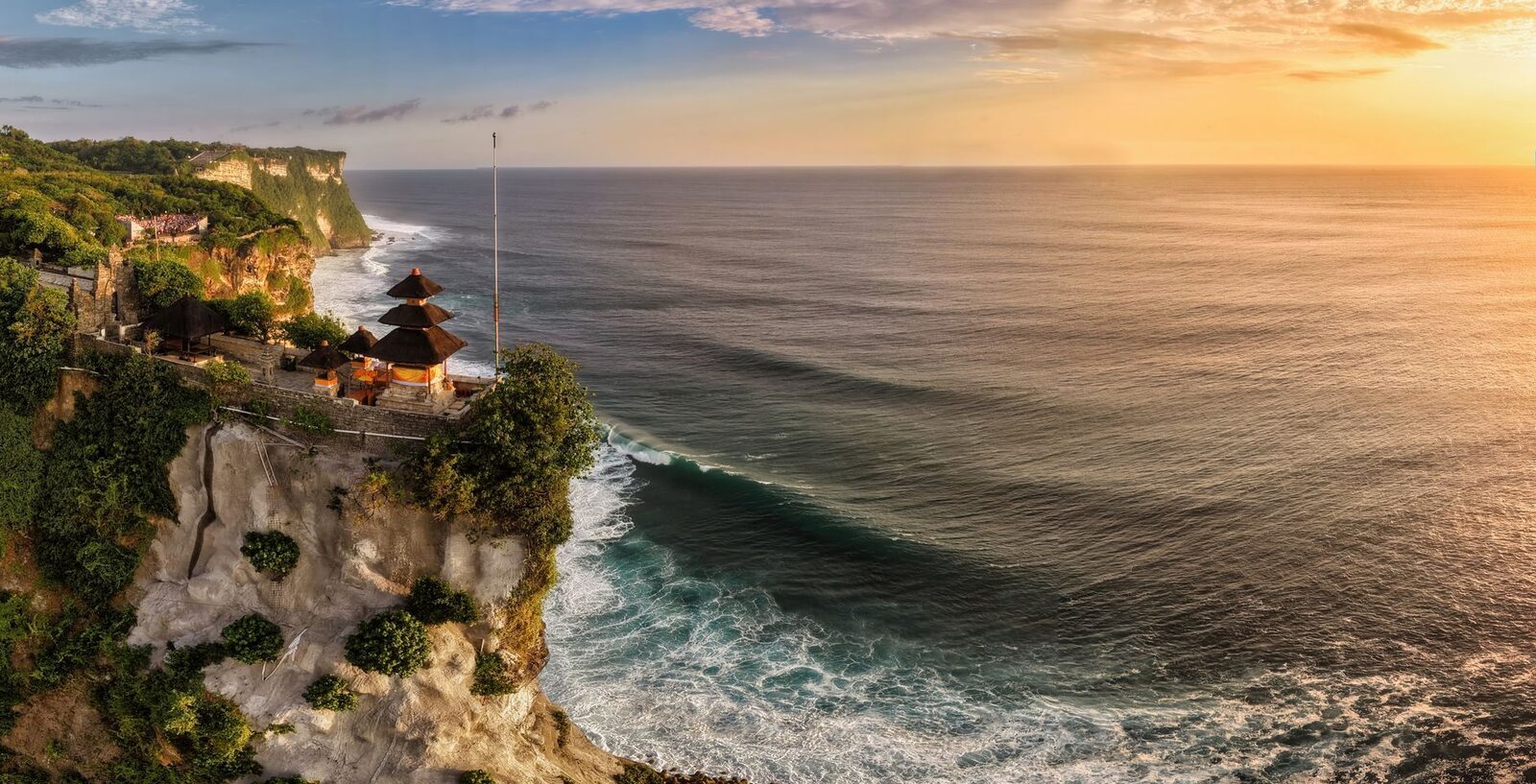 Uluwatu temple at golden hour, the sea catching the light.