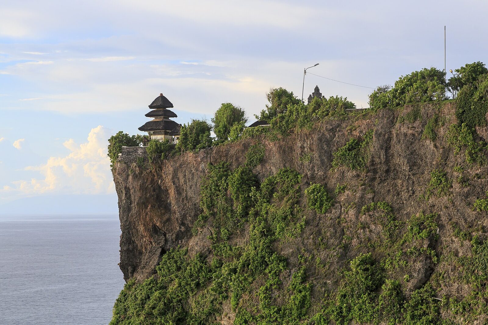 Pura Luhur Uluwatu — the temple's meru shrines perched on the cliff edge above the Indian Ocean.