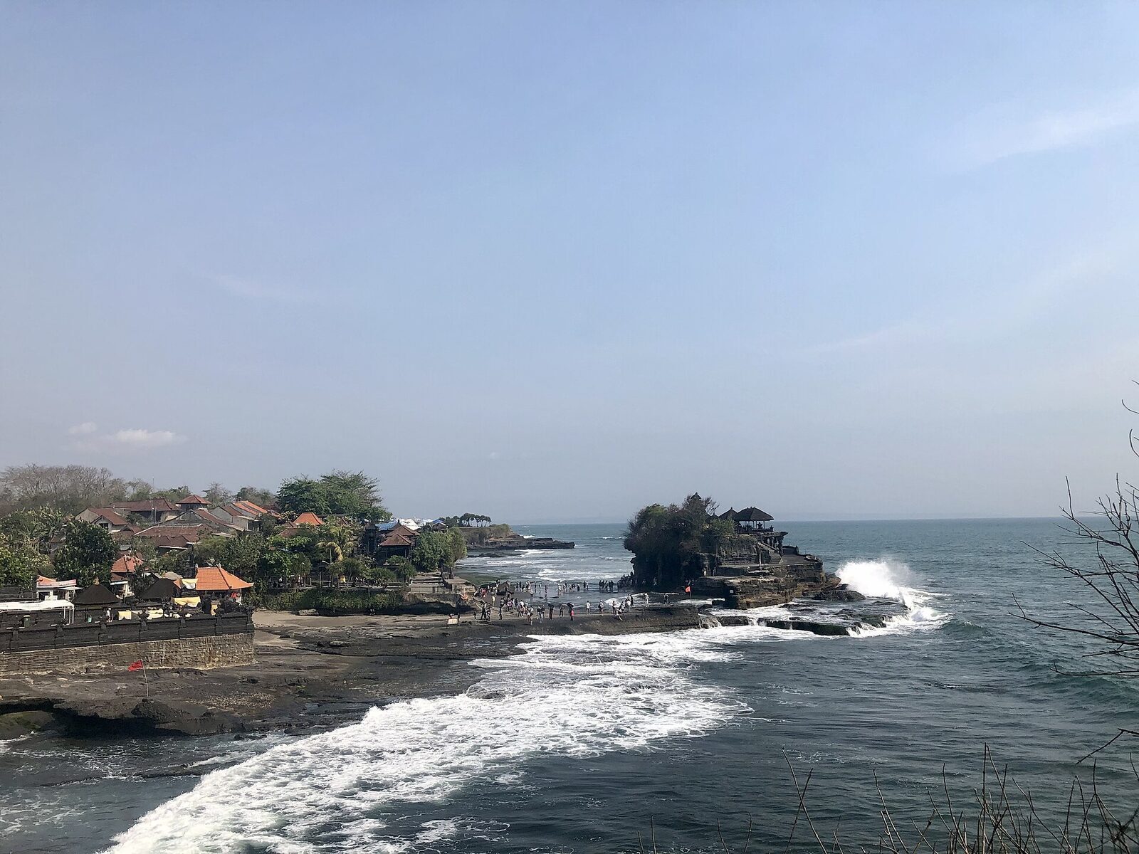 Waves wrapping the base of Tanah Lot's rock at high tide.