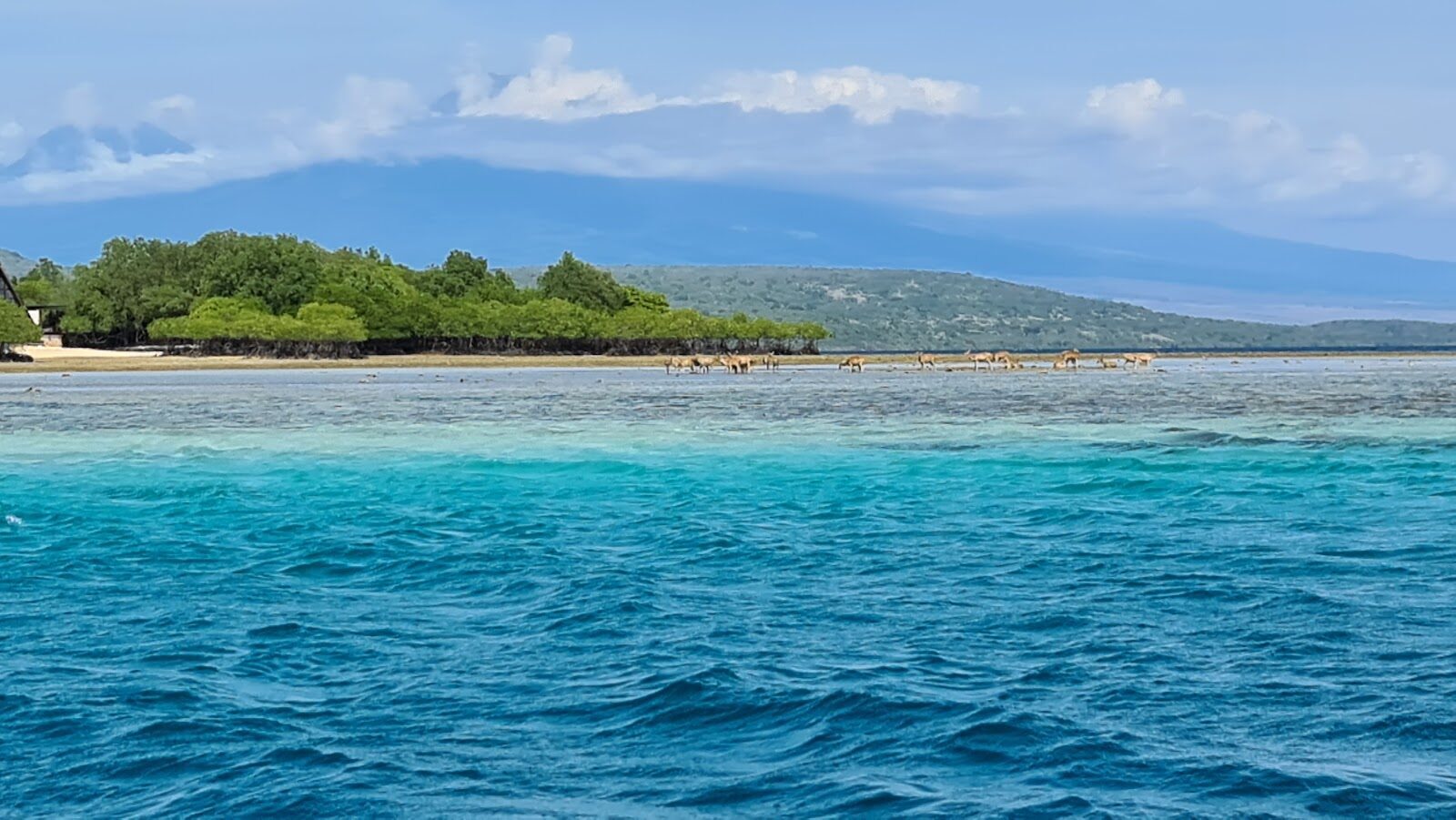 A calm, clear lagoon backed by low hills on the quiet north-west coast.