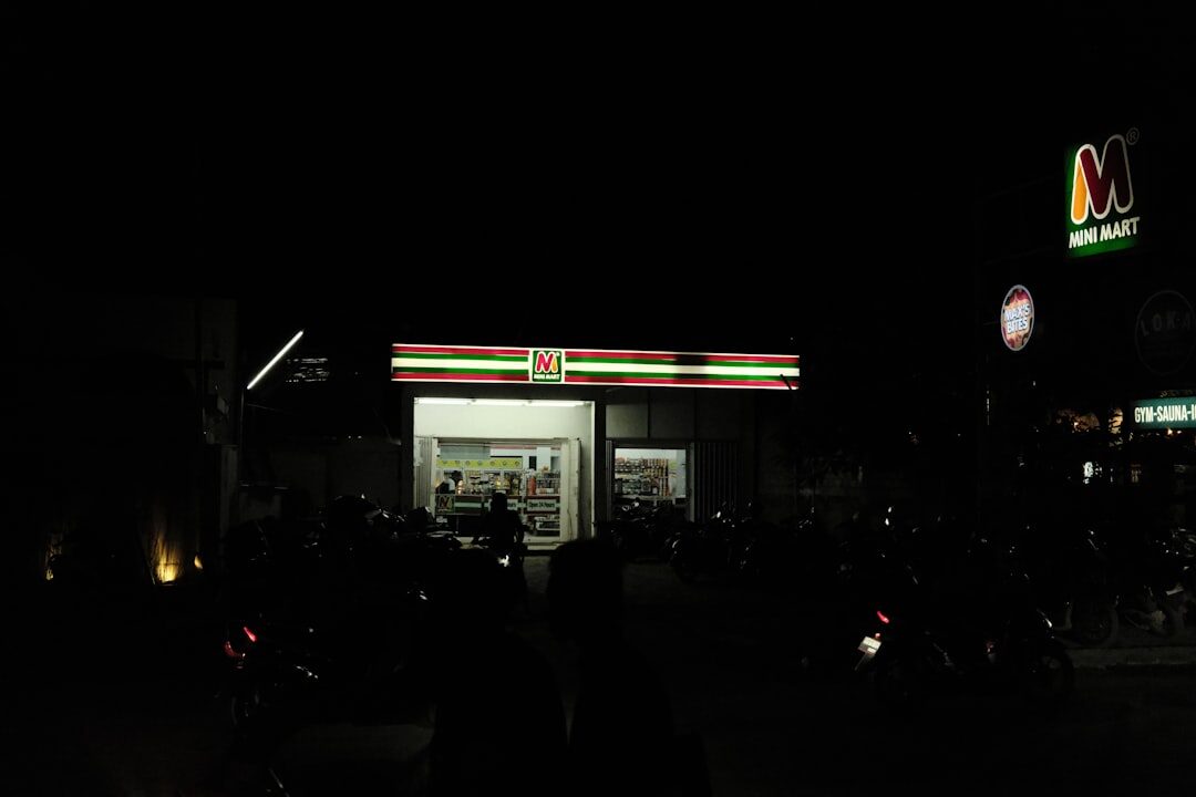 A minimart glowing at night on the Kuta strip — cheap, central and loud, and not the island's prettiest side after dark.