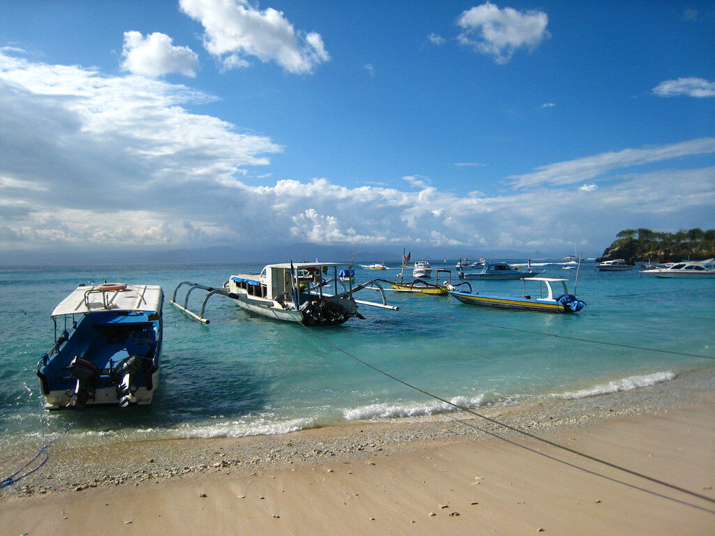 Fast boats loading off the beach — the crossing is short, but the islands' infrastructure is thin once you're there.