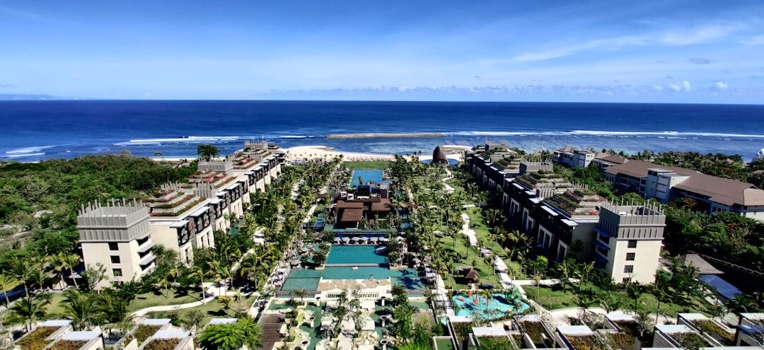 The manicured Nusa Dua resort enclave from above — pools, lawns and big hotels, gated off from the road.