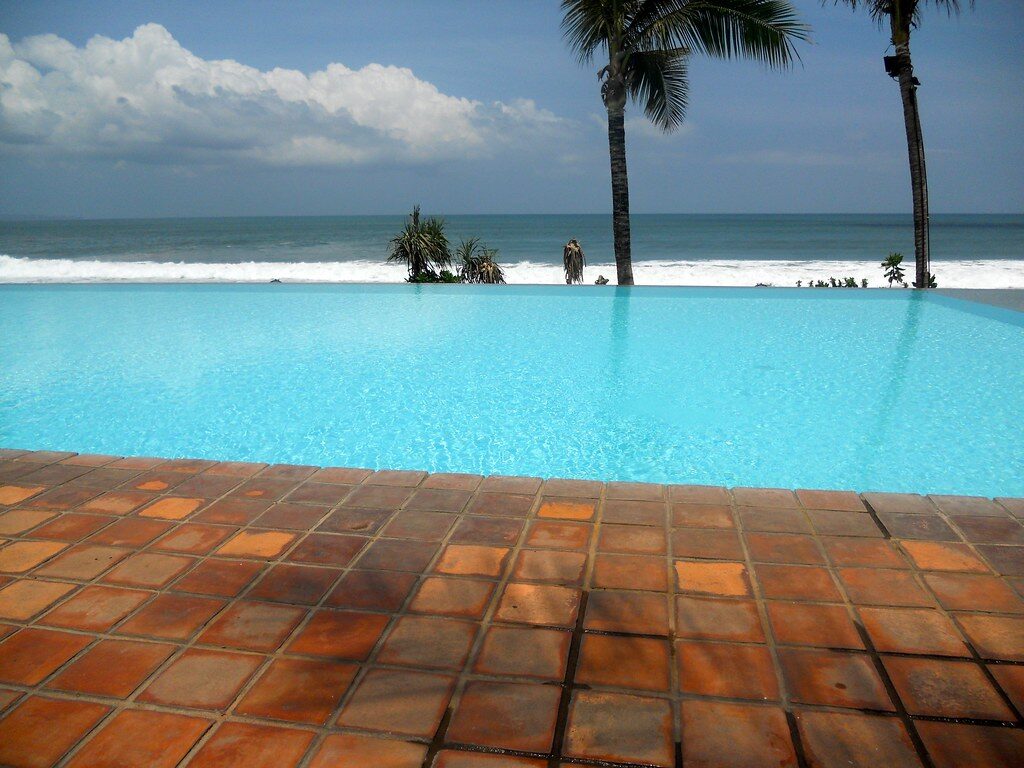An infinity pool running out toward the sea — the comfortable, walkable end of the coast.
