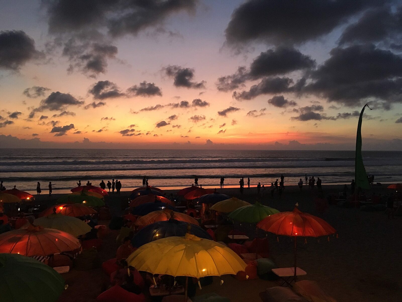 Beach-club umbrellas lined up for the Seminyak sunset — the polished, designed version of a Bali beach day.